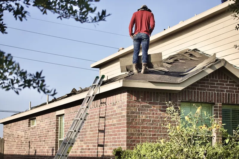 Professional roofer working on a residential roof in Stringtown